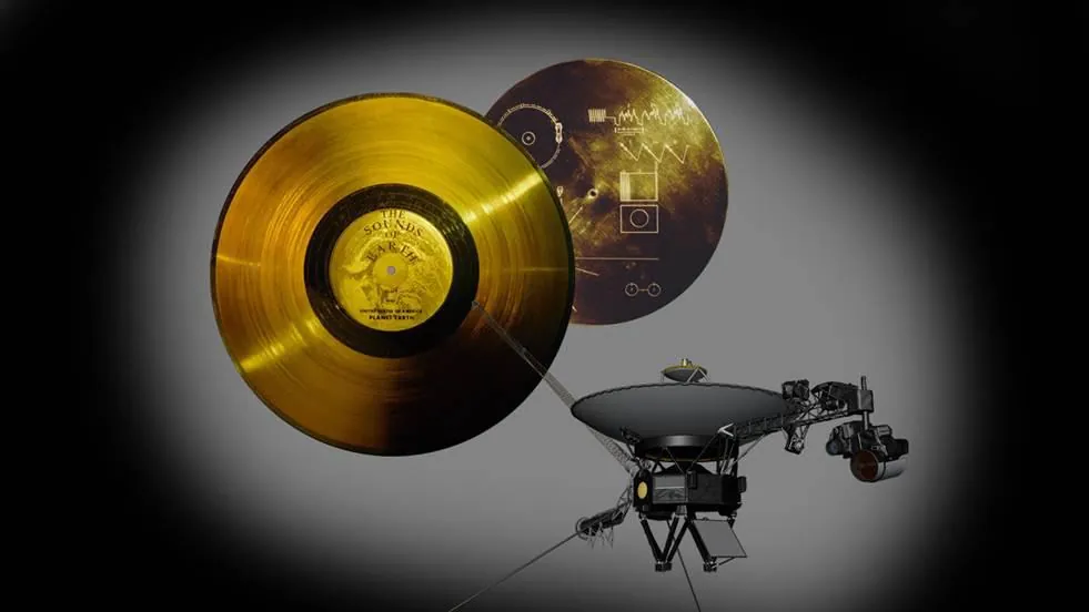 A gold-plated record disc and its cover beside a Voyager spacecraft