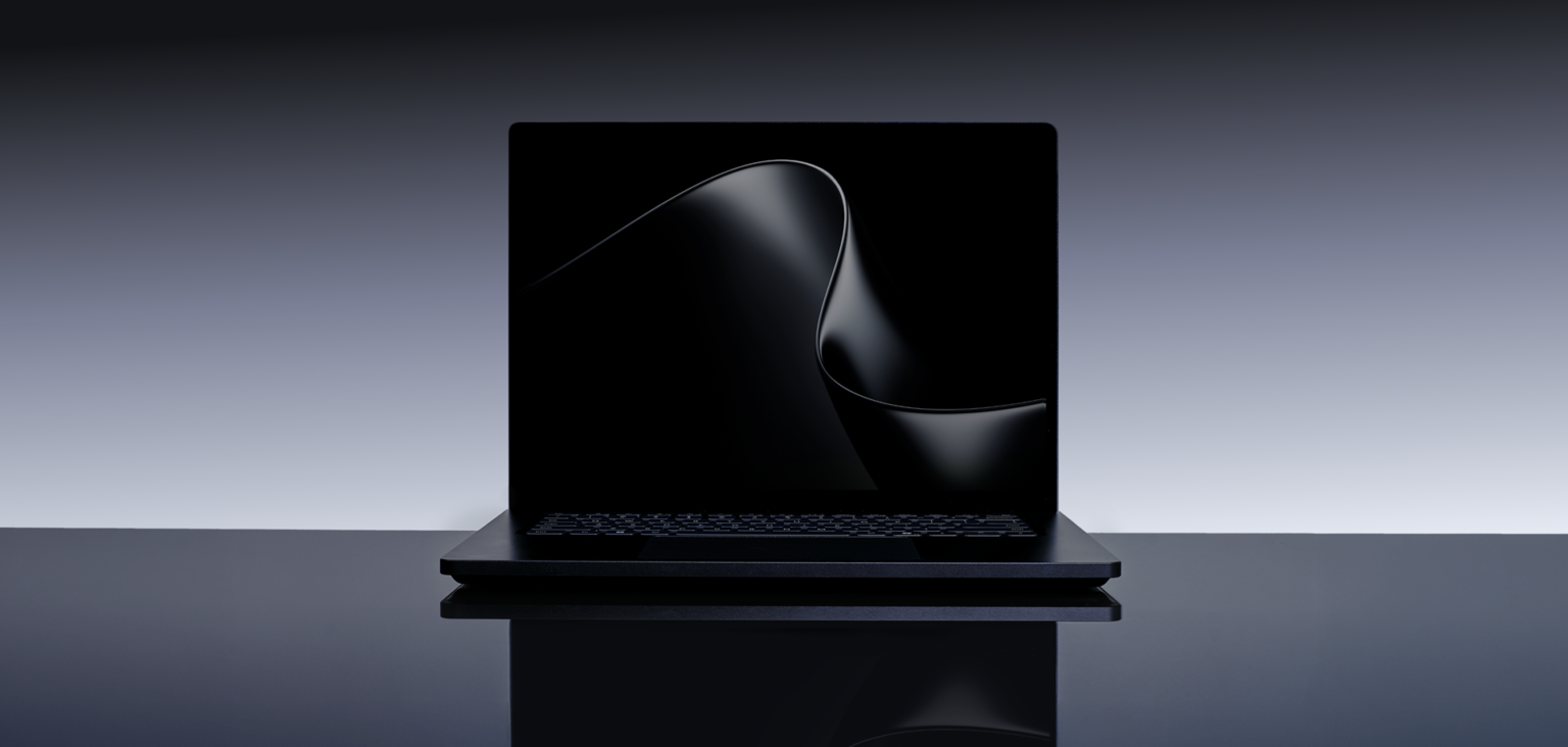 A black Surface Laptop Ultra open on a reflective dark surface